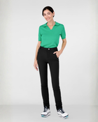 Woman wearing a green cashmere polo shirt and black athletic leisure Inka  pants 